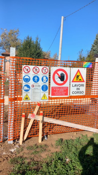 Pannello di segnaletica di sicurezza affisso alla recinzione di un cantiere, con cartelli DPI e divieto d'accesso ai non addetti