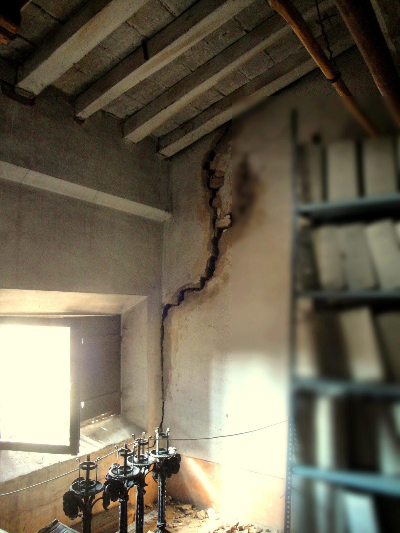 Crepa diagonale che attraversa la parete dal soffitto al pavimento in un ambiente in ristrutturazione