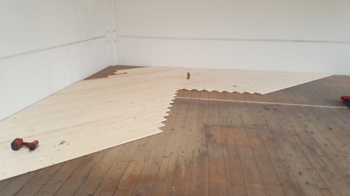 Posa di una nuova pavimentazione in legno su un edificio produttivo, al termine dell'intervento