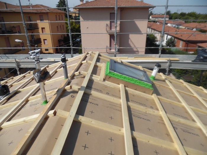 La struttura di copertura di un cantiere in corso, vista dall'alto, con ponteggi e un lucernario in fase di posa