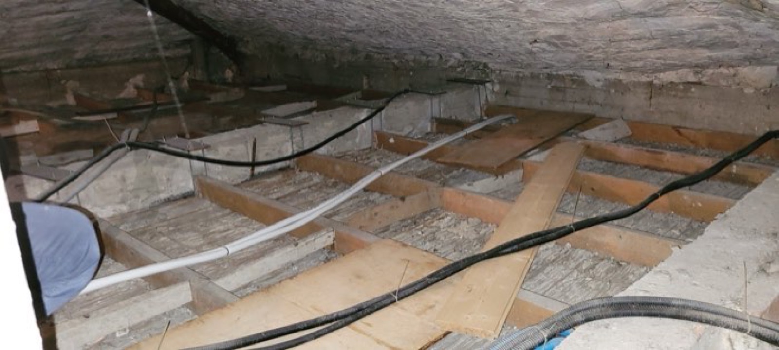 Intradosso del tetto in un sottotetto in fase di recupero, con travetti in legno e canaline elettriche in posa