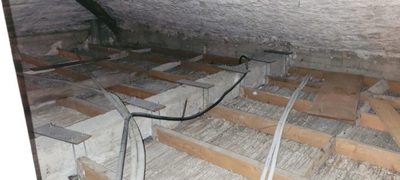 Fila di plinti con staffe metalliche a vista, predisposti per il nuovo solaio di un sottotetto