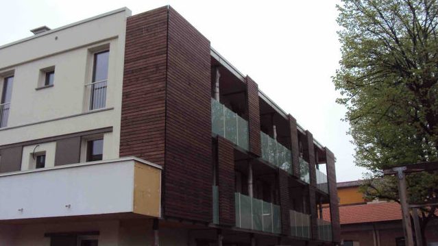 Facciata laterale con rivestimento e balconi